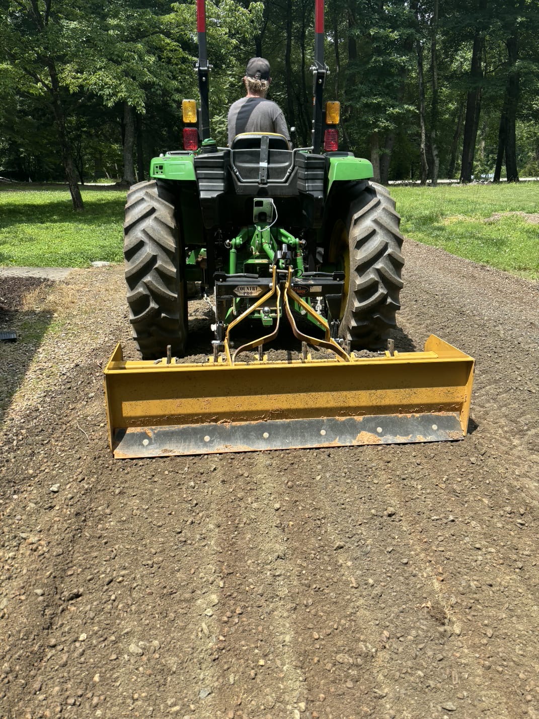 Tractor with box blade spreading driveway gravel
